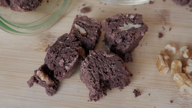 Chopped brownie cookies and walnuts on wooden board for sweet treat