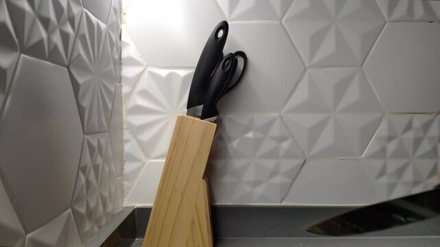 Knife block on kitchen counter with geometric tiles, modern vibe
