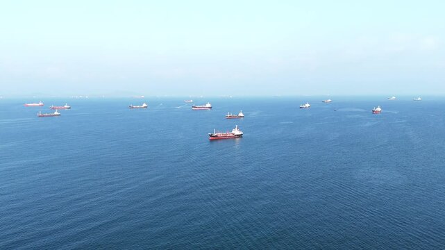 fast patrol boat LPG gas and oil tanker ships anchored in the ocean, with a fast patrol boat in the foreground. Global energy transport, war energy crisis, and Strait of Hormuz blockade