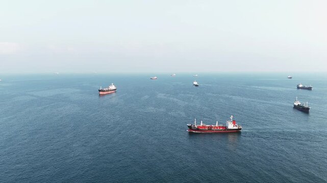 fast patrol boat LPG gas and oil tanker ships anchored in the ocean, with a fast patrol boat in the foreground. Global energy transport, war energy crisis, and Strait of Hormuz blockade