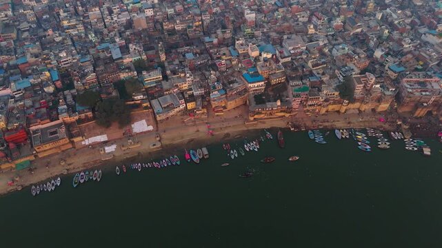 Drone aerial view of Varanasi ghats and Ganges River, India, featuring temples, boats, and historic riverside landscape.