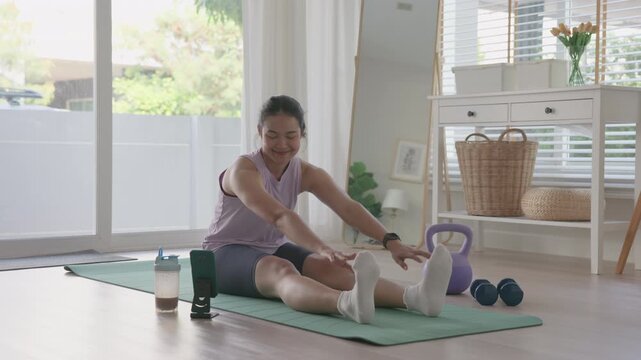 Young active asia people woman using smart phone watch learn online AI gym class home workout video app Health care sport club internet of things happy relax enjoy yoga anti aging life weight loss.