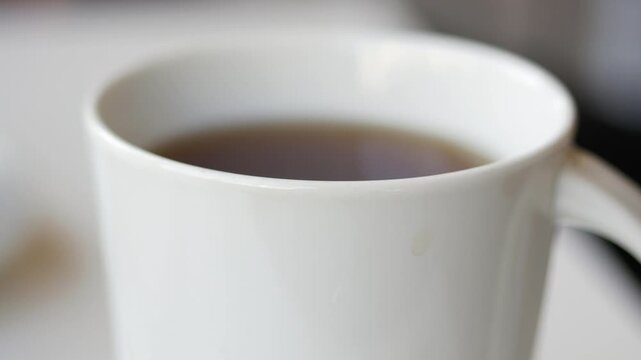 Enjoy coffee in a white mug at a cozy cafe setting
