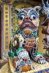 Fototapeta premium Colorful sculpture of Oriental lion decorated entrance of Linh Phuoc Pagoda in Da Lat, Vietnam. Temple is built from shards of ceramics, glass and old beer bottles