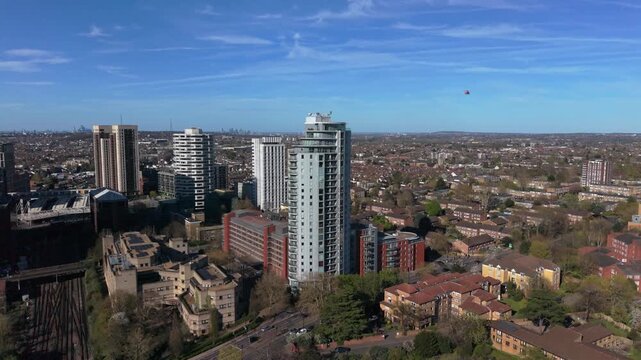Aerial view of rescue helicopter landing in public park in Croydon, UK. Sudden appearance of low flying ambulance helicopter in urban area. Top down view of helicopter landed on open green.