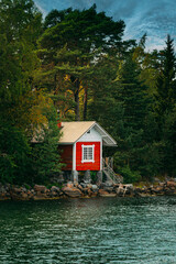 Fototapeta premium Traditional Red Cabin on a Rocky Shoreline