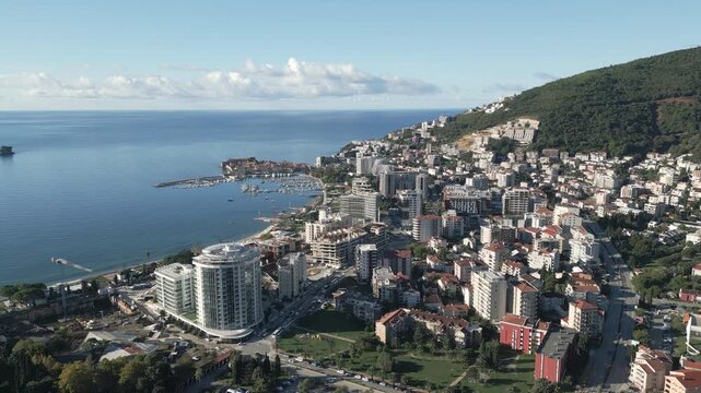 Aerial panorama of the Budva cityscape and Adriatic coastline on a sunny day, southern Montenegro.