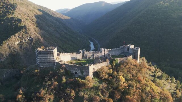 Golden hour cinematic view of the medieval Maglic castle and Ibar river valley in western Serbia.