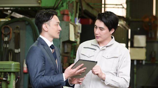 製造業の工場でタブレットを持つ作業員と信金などの打ち合わせをする営業ビジネスマンの2人　設備投資で業務効率などの借り入れのイメージ動画
