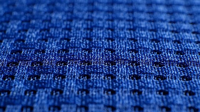 Close up of a blue textile with a repeating geometric pattern