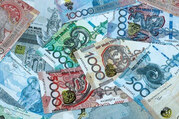 Fototapeta premium Kazakhstani tenge money banknotes pile on table. Kazakhstan bills of KZT currency close up