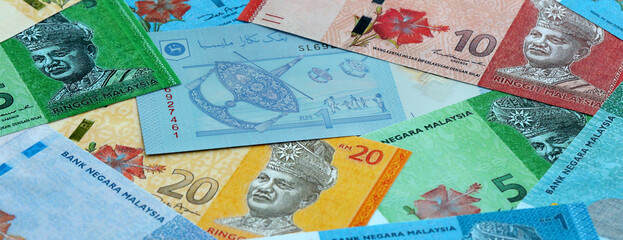 Malaysian ringgit money banknotes pile on table. Malaysia bills of MYR currency close up © Larysa