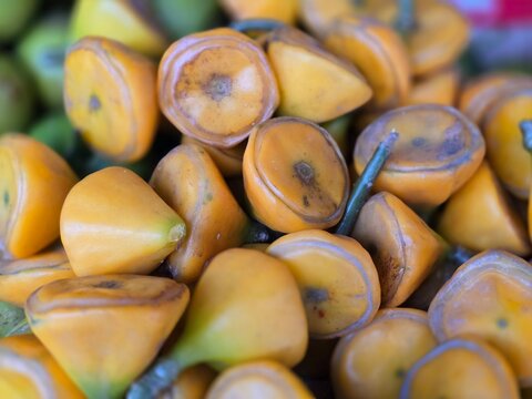 Fresh Pereskia bleo fruits displayed for sale in a local market, showcasing their natural texture and unique appearance. Ideal for exotic fruits, medicinal plants, agriculture.