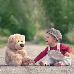 little boy playing with toy bear in spring season © Jenny Sturm