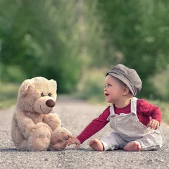 little boy playing with toy bear in spring season © Jenny Sturm