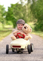 cute girl with her teddy is riding a pedal car © Jenny Sturm