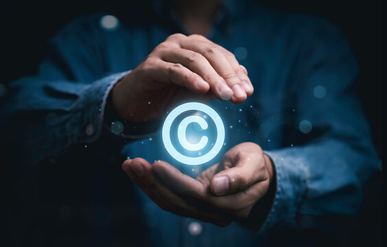 Copyright protection concept with glowing copyright symbol in hands represent intellectual property rights, digital ownership, legal security, content protection, and safeguarding creative assets.