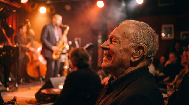 older man with hearing aid enjoying live jazz performance for assisted listening awareness active aging nightlife culture entertainment accessibility campaigns live music venue promotion