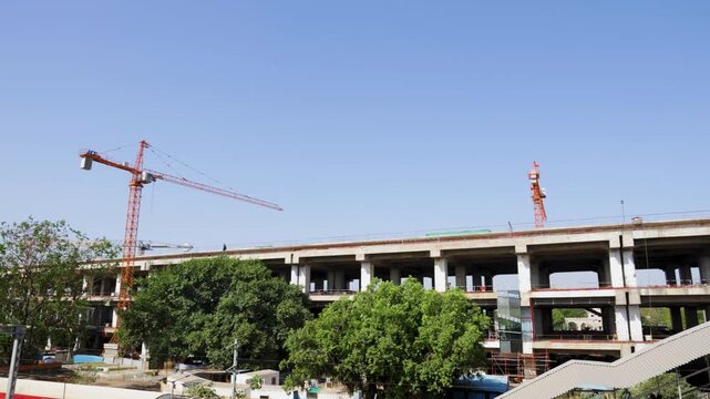 multi level construction site with cranes and unfinished concrete building