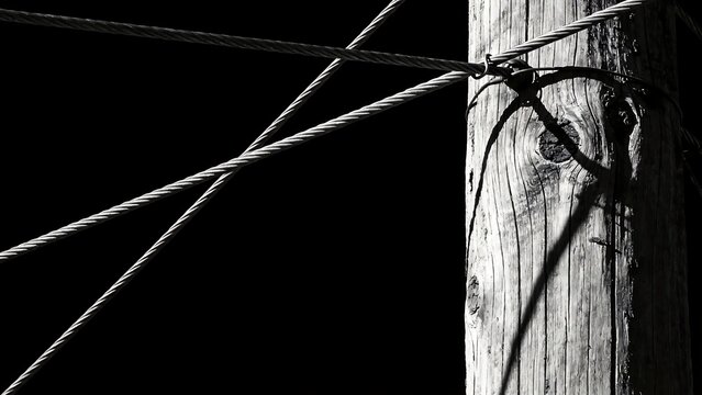 Wooden pole with cables against dark background