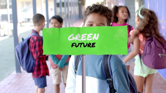 Main boy holding GREEN FUTURE sign facing camera, sparking animated leaves and charts for education