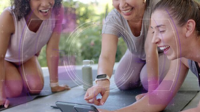 Three women kneeling on mats tapping smartphone and watching HUD graphics animating fitness stats