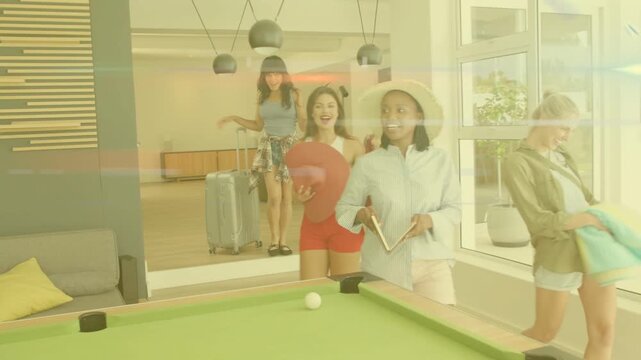 Group of four women entering glass lounge, walking to green-felt pool table, unpacking for travel