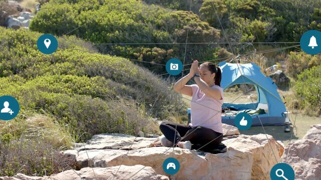 Woman raising, lowering hands on coastal rock, icons moving inward linking her to tent for health