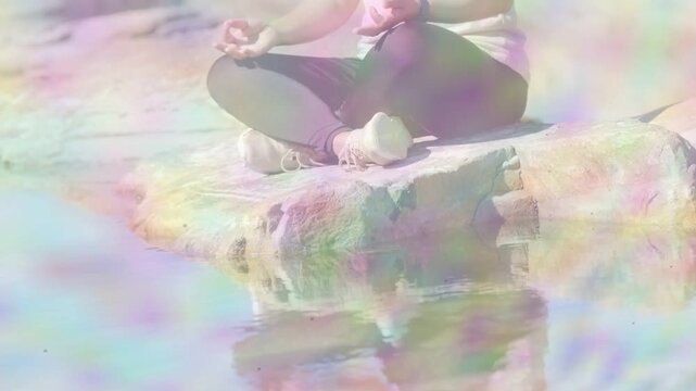Camera panning up, woman sitting with legs crossed forming mudra, pastel haze rising for wellness