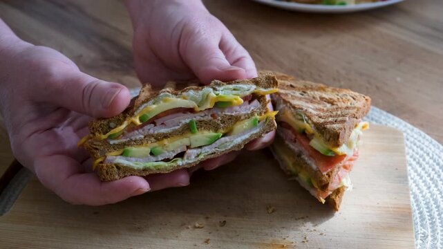Club sandwiches with guacamole and fresh vegetables show the cut