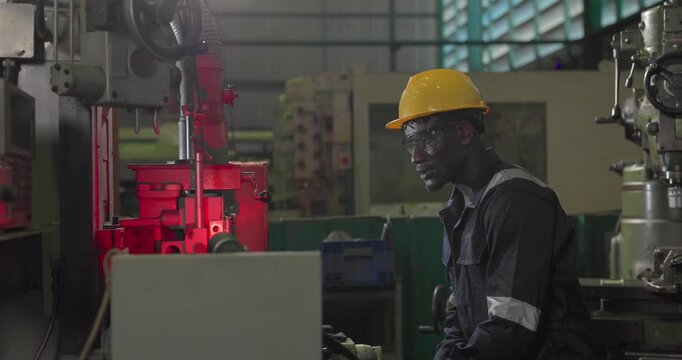 A technician performs precision grinding and close inspection on a metal component in a manufacturing facility, showing finishing work, process control, and industrial supervision.
