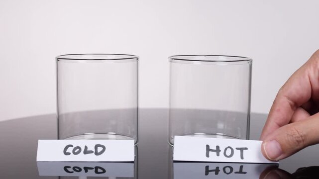 Two empty glasses labeled cold and hot, ready for a science experiment demonstration.