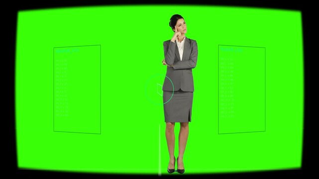 Camera cue starting female exec shifting poses, touching chin, smiling, greenscreen marker on hip