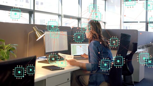 Office worker reviewing paper, verifying data on monitors while AI overlay following cursor