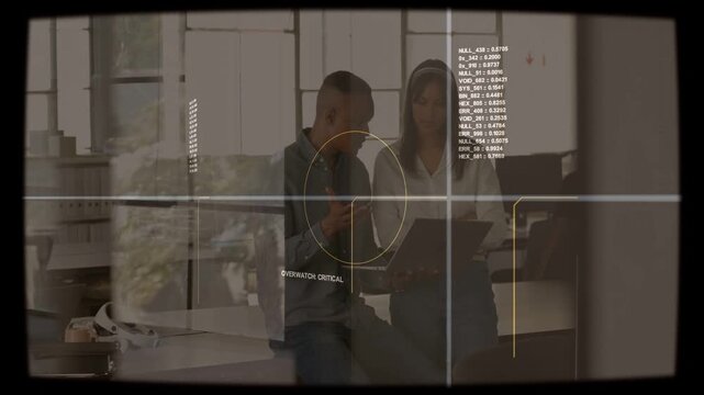 Team at desk, man tapping device while woman reviewing tablet, HUD overlay confirming business info