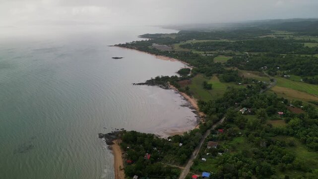 Aerial view of Guimaras Island's coastline featuring lush greenery and a wide shoreline. Ideal for travel content or environmental documentaries.