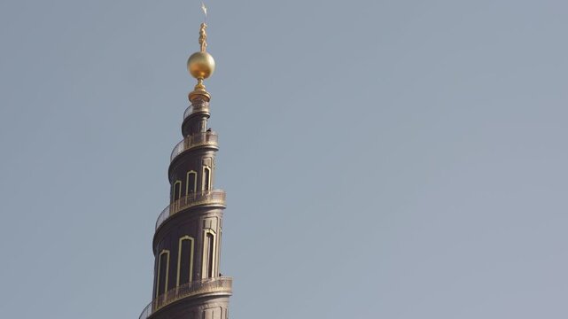 The iconic spire of Our Saviour&rsquo;s Church (Vor Frelsers Kirke) in Christianshavn, Copenhagen, rising into a clear blue sky on a sunny day, showcasing its distinctive spiral tower and historic architect