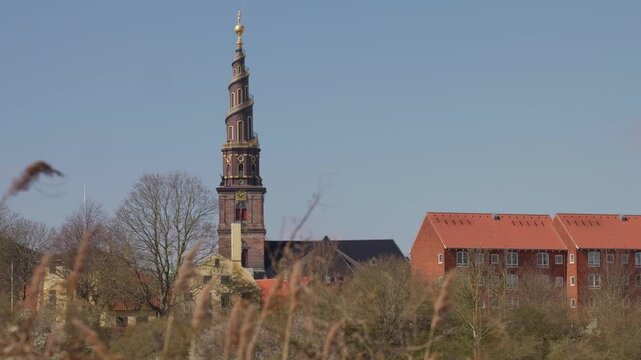 The iconic spire of Our Saviour&rsquo;s Church (Vor Frelsers Kirke) in Christianshavn, Copenhagen, rising into a clear blue sky on a sunny day, showcasing its distinctive spiral tower and historic architect