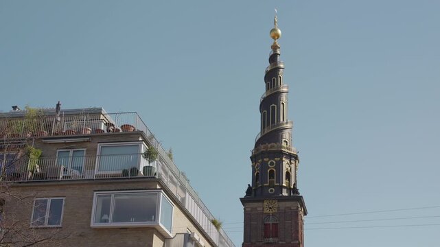 The iconic spire of Our Saviour&rsquo;s Church (Vor Frelsers Kirke) in Christianshavn, Copenhagen, rising into a clear blue sky on a sunny day, showcasing its distinctive spiral tower and historic architect