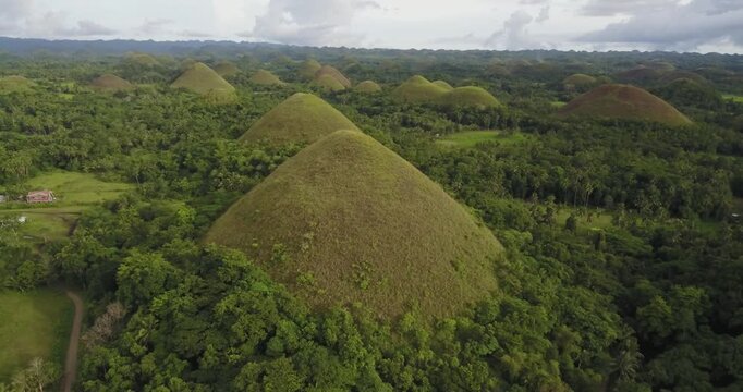 Aerial drone shot orbiting from right to left around the famous Chocolate Hills in Bohol Philippines, showcasing lush tropical landscape and iconic cone shaped hills