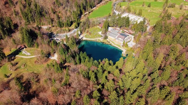 Aerial: Blausee in Bernese Oberland during the day in Kandergrund, canton of Bern, Switzerland, orbit drone shot