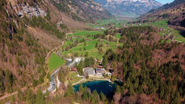 Aerial: Blausee, Kander river and Kandertal valley in Bernese Oberland during the day in Kandergrund, canton of Bern, Switzerland, pull out drone shot