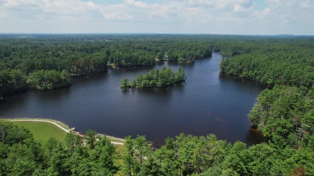Drone orbit view of calm lake and green pine forest at Harold Parker State Forest, Massachusetts, USA