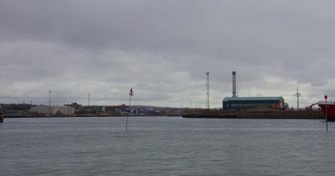 Wide shot of a tugboat and large ship entering Shoreham harbour