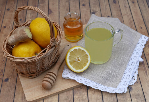 Frisches Ingwerwasser mit Zitrone und Honig in Glaskaraffe und Tasse. Gesundes Hausmittel zur St&auml;rkung der Abwehrkr&auml;fte.
