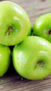 Vertical video: Shifting lens zooming to top apple showing stem on rustic table with binary overlay
