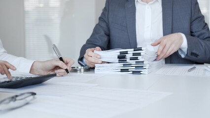 Fototapeta na wymiar Business people reviewing financial documents, calculating tax, auditing corporate accounting records, and processing paperwork in office. Audit and taxes in business