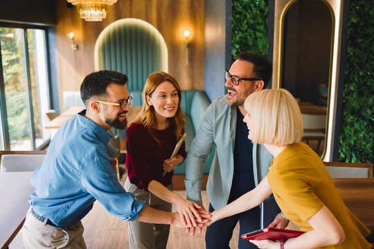 Business team stacking hands in gesture of unity and teamwork