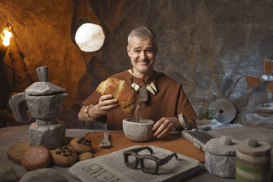 Happy caveman having breakfast and smiling at the camera