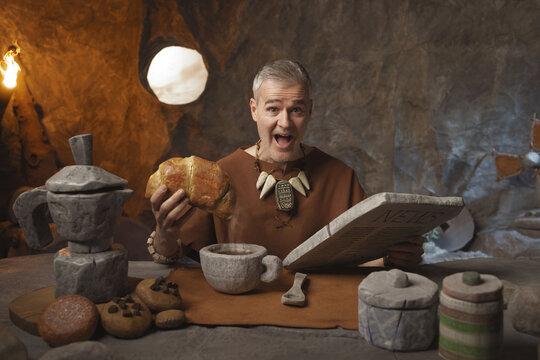 Happy caveman having breakfast and smiling at the camera